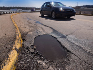 Car driving by pothole